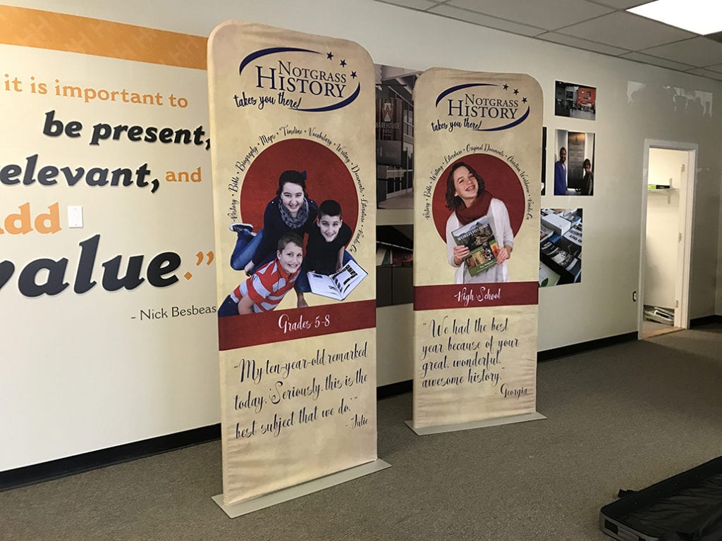 two signs for a brand with smiling children on the posters.