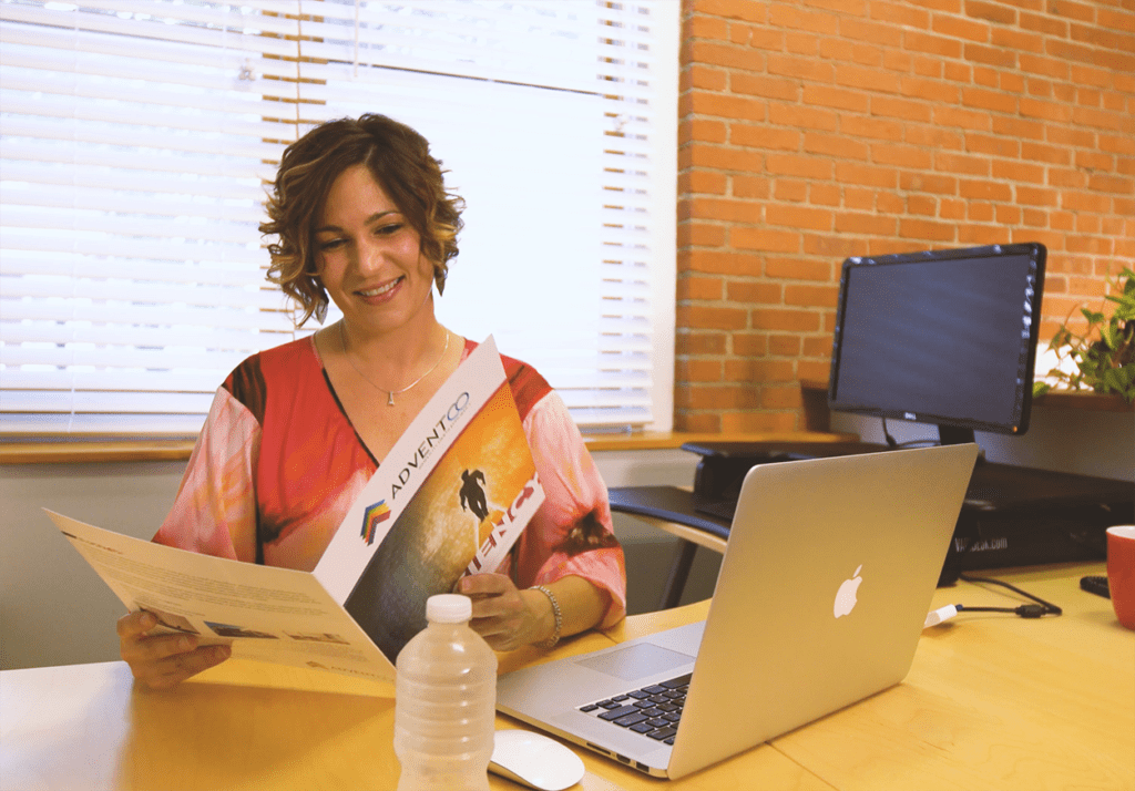 woman reading brochure at desk