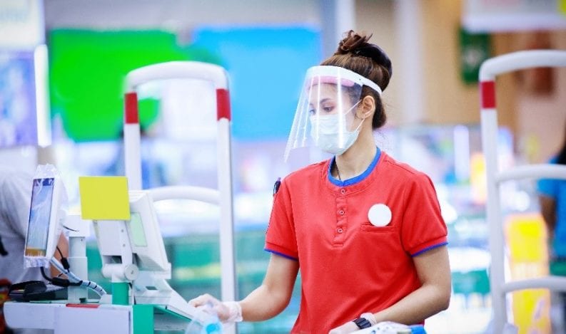 Cashier wearing face protection
