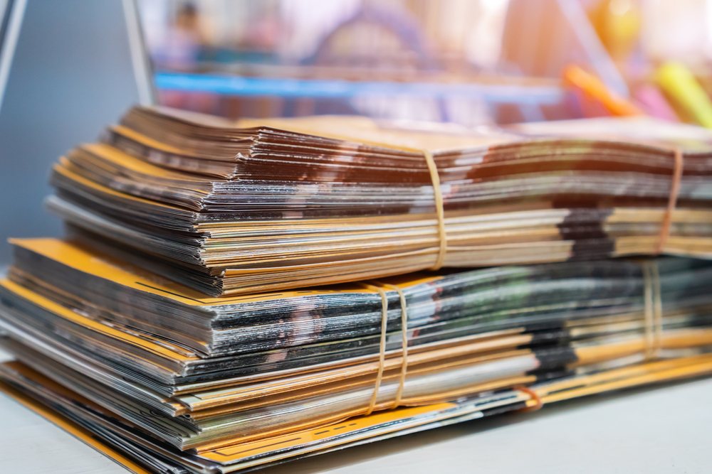 Stack of brochures and documents rubber banded together for print marketing