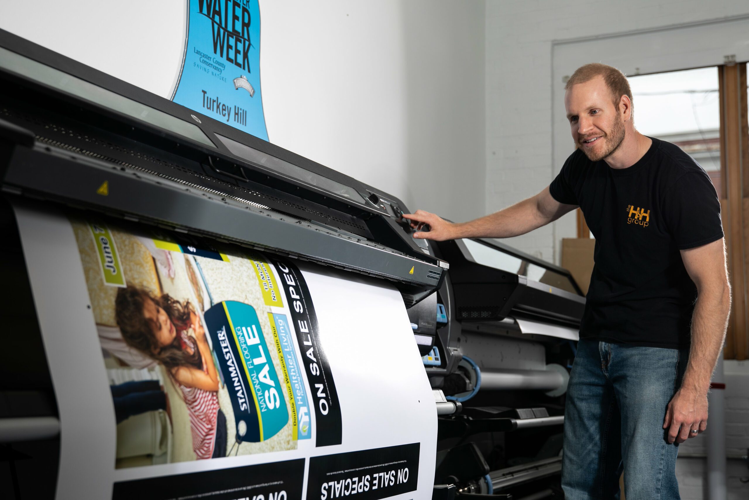man checks on a large printer