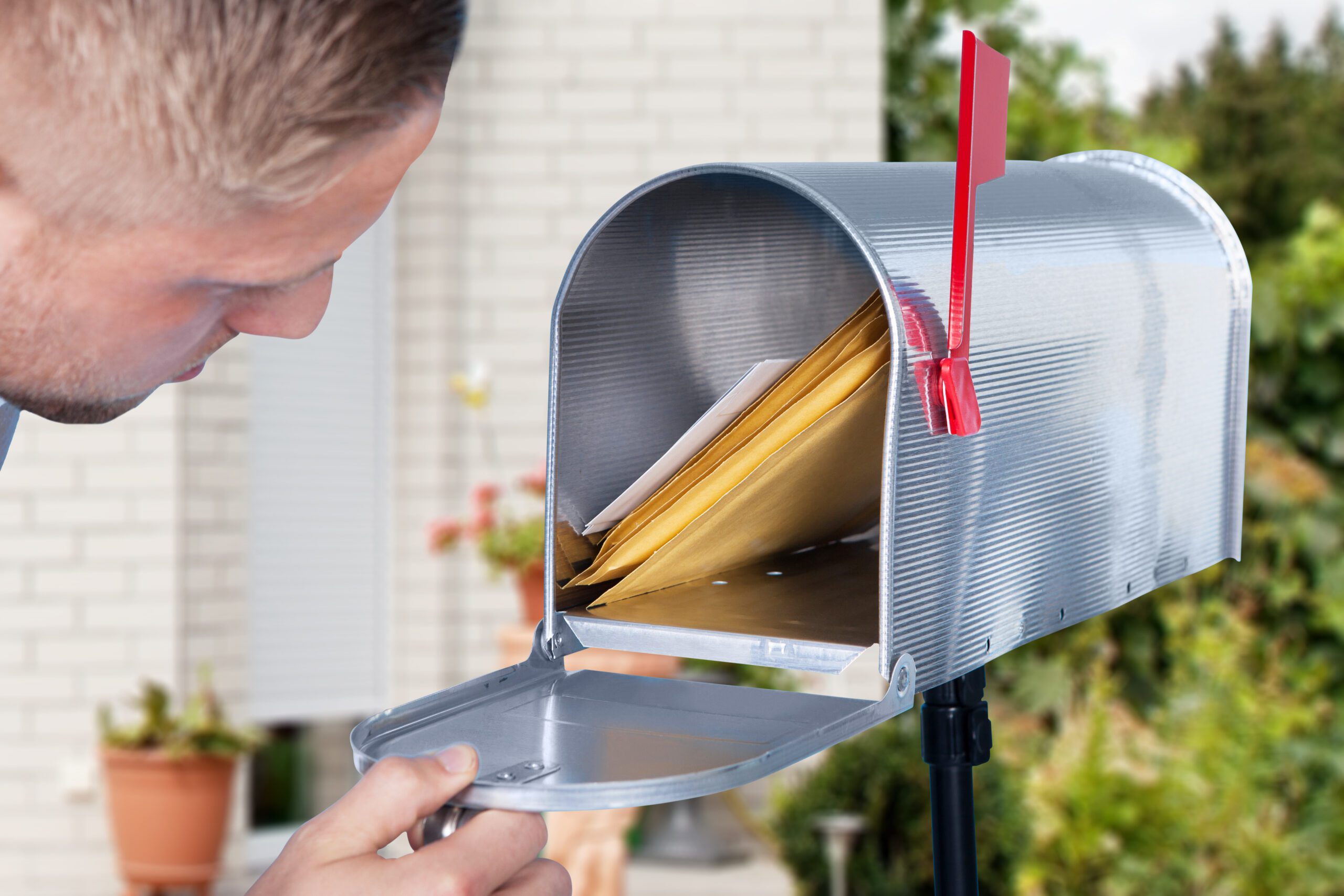 A man looks into his mailbox to see mail
