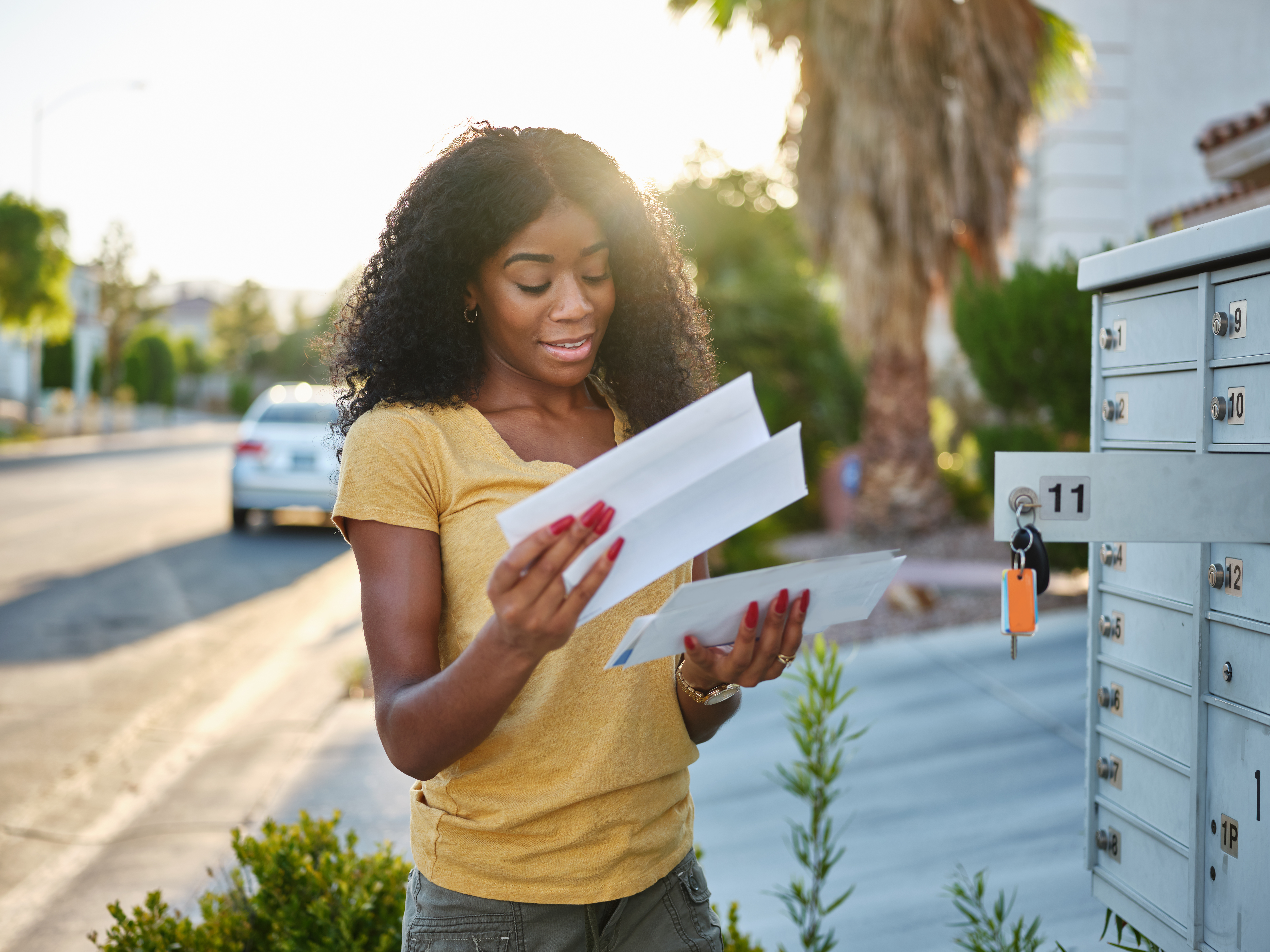 A woman checks her mailbox and goes through her mail