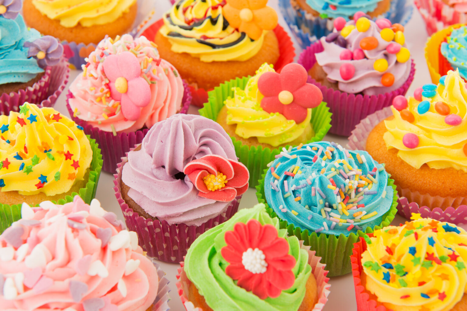 A group of cupcakes with colorful frosting and sprinkles.