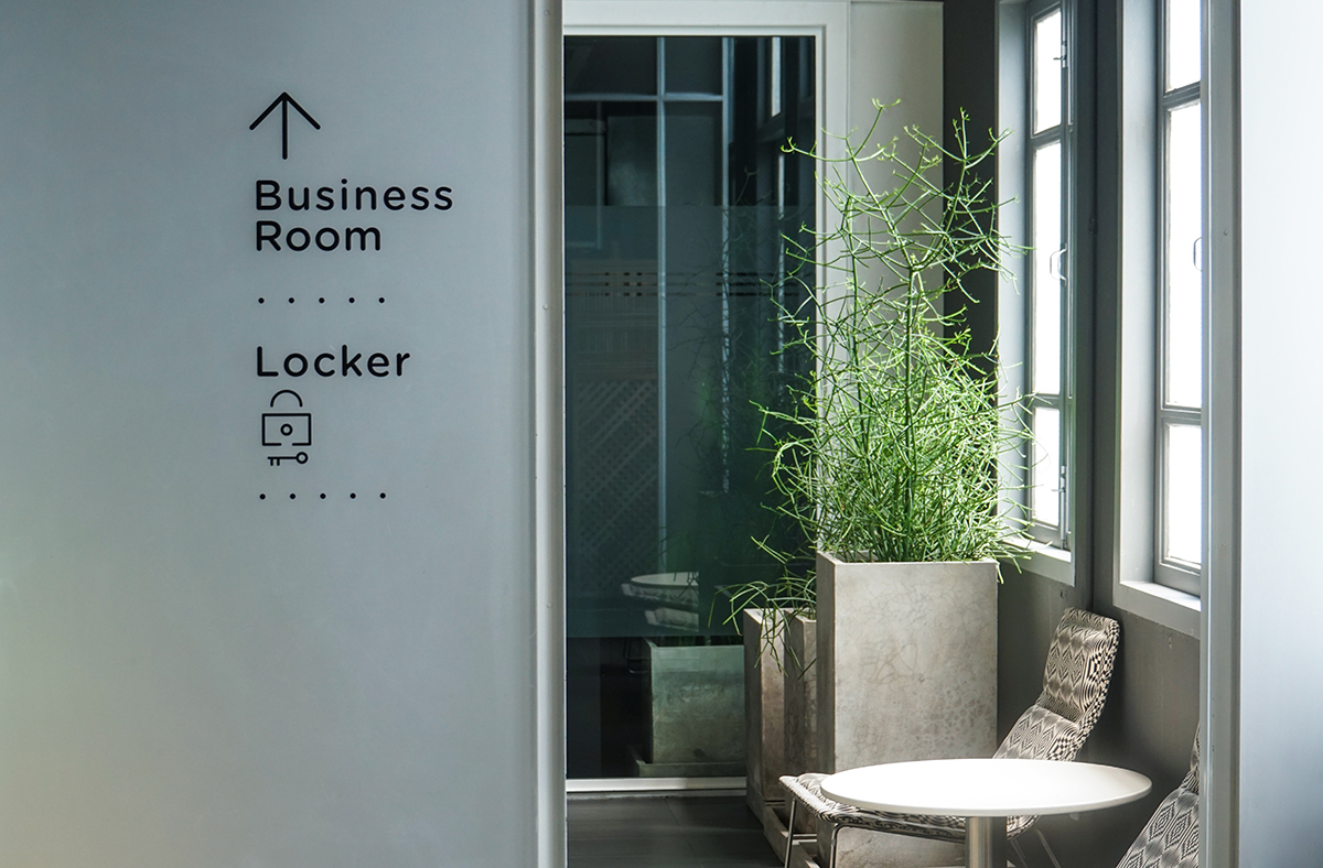 A photo of a sign indicating where the locker room and the business room are located in an office.
