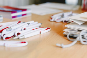 A pile of pens and bags to give away at a promotional event.