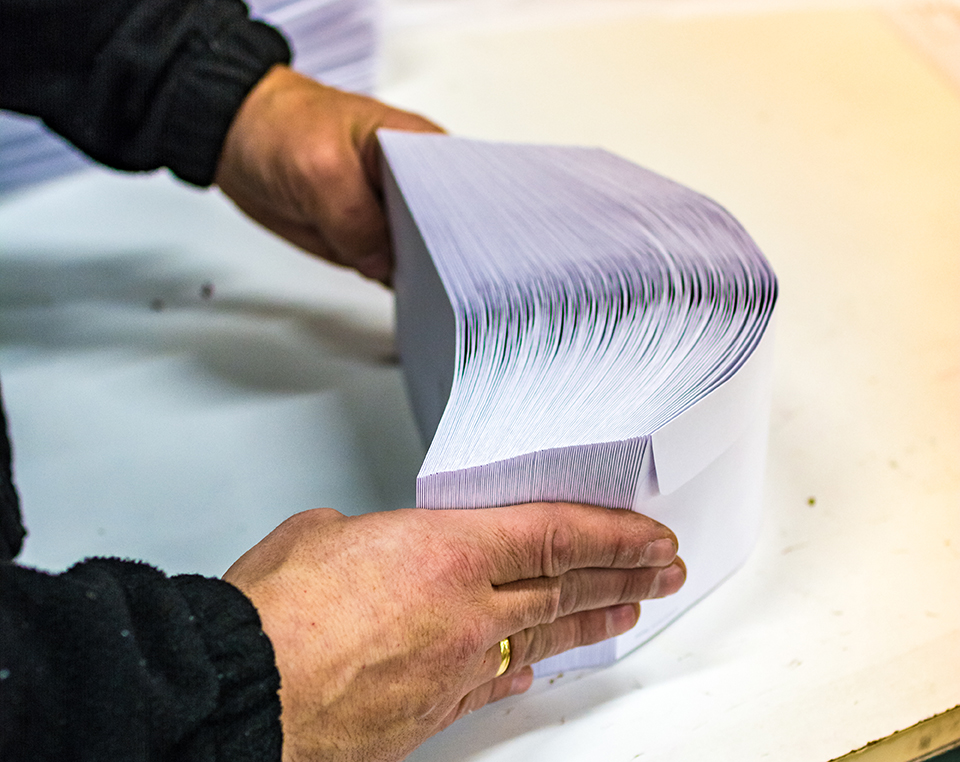 An image of a person holding a stack of envelopes