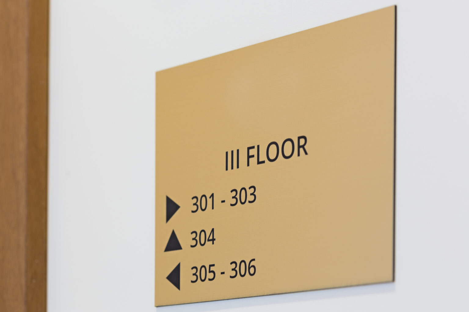 A yellow sign that has directions for the third floor, indicating where the room numbers are, with arrows.