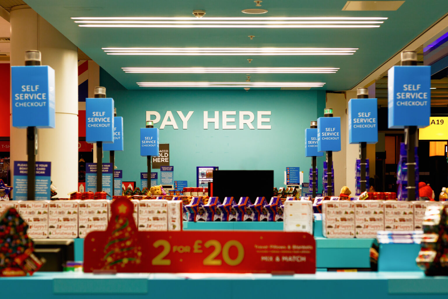 A busy store during the holiday season, with a large white ‘pay here’ sign over the general checkout area.