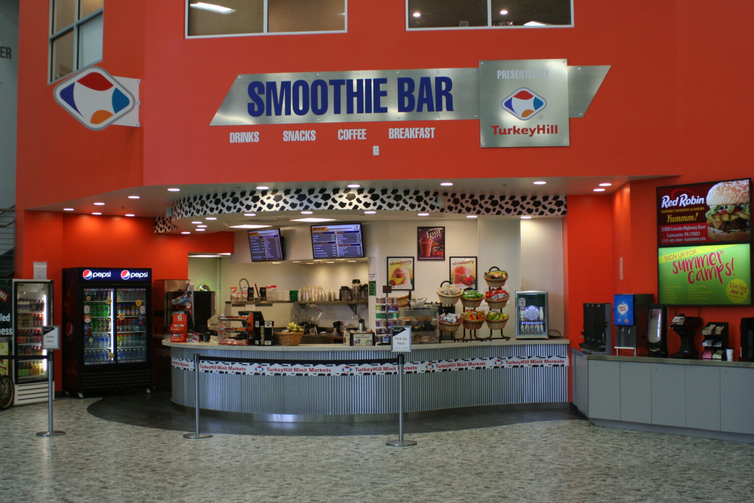 A bright wall graphic that says “smoothie bar” in blue letters on a silver metal background.