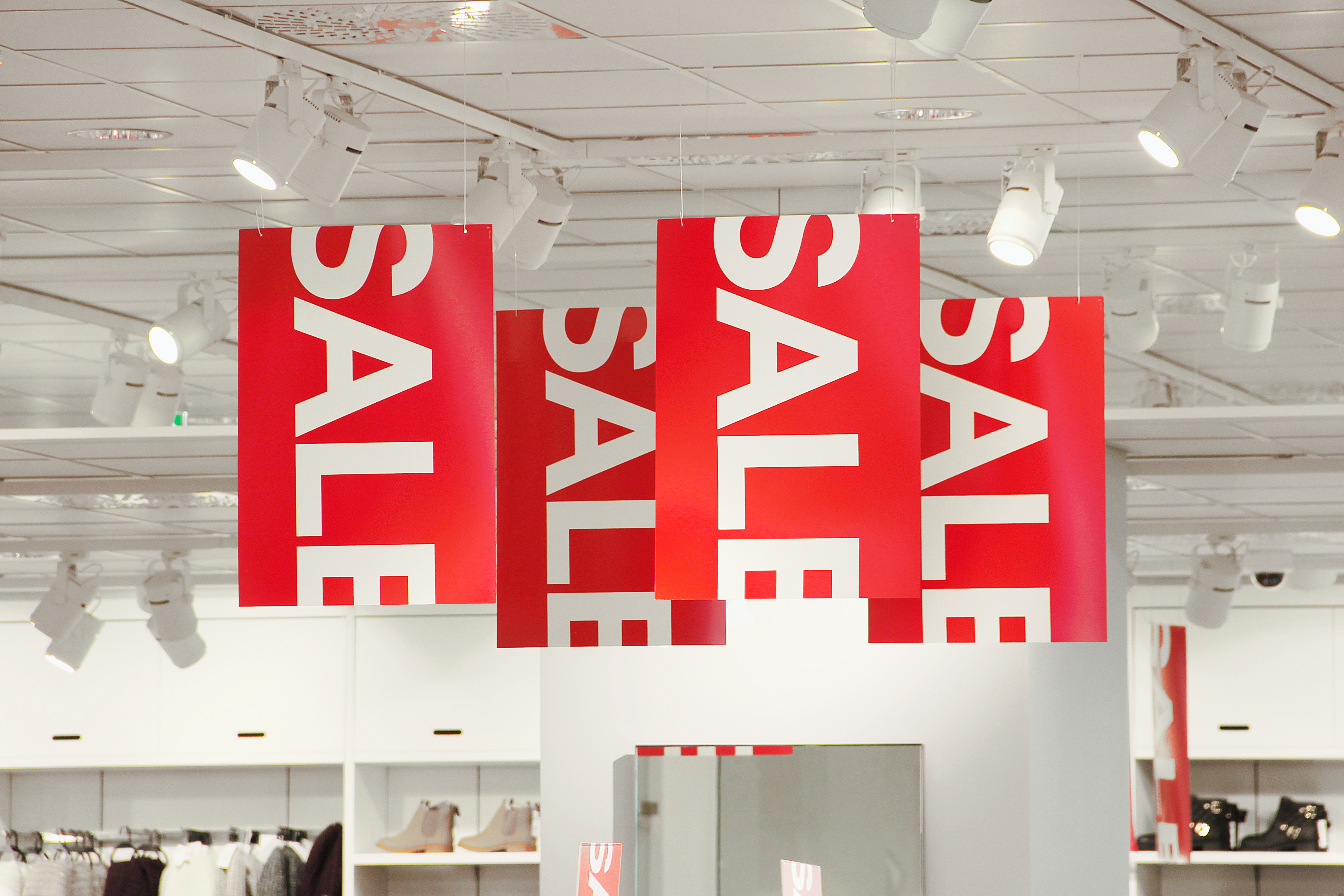 Red sale banners hanging from a ceiling